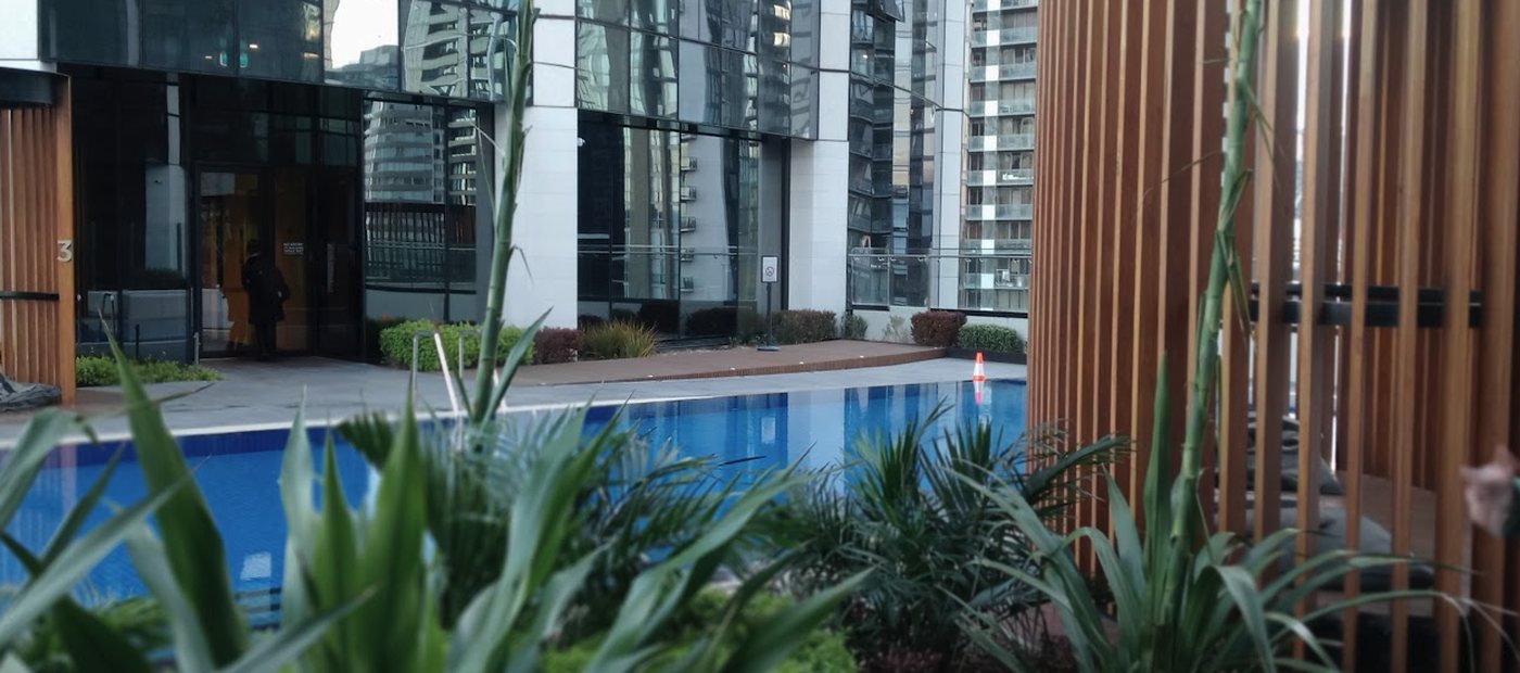 Residential tower common property with landscaped amenity area and building reflections